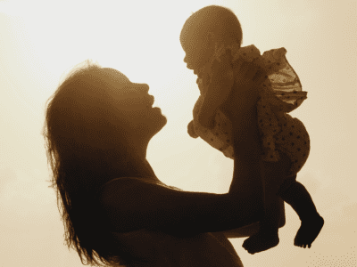 Silhouette of mom and child at sunset