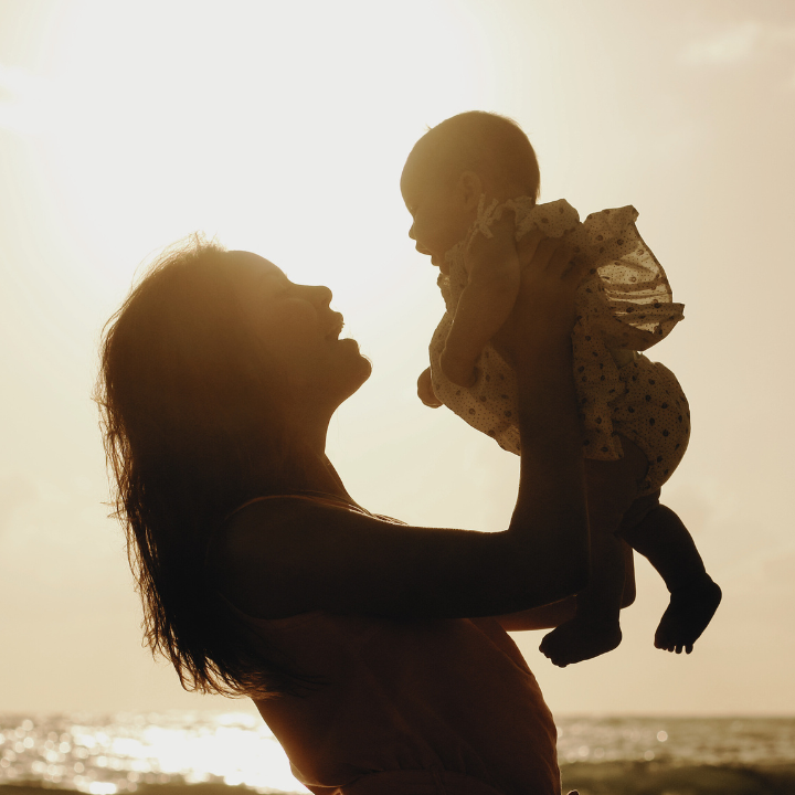 Silhouette of mom and child at sunset 